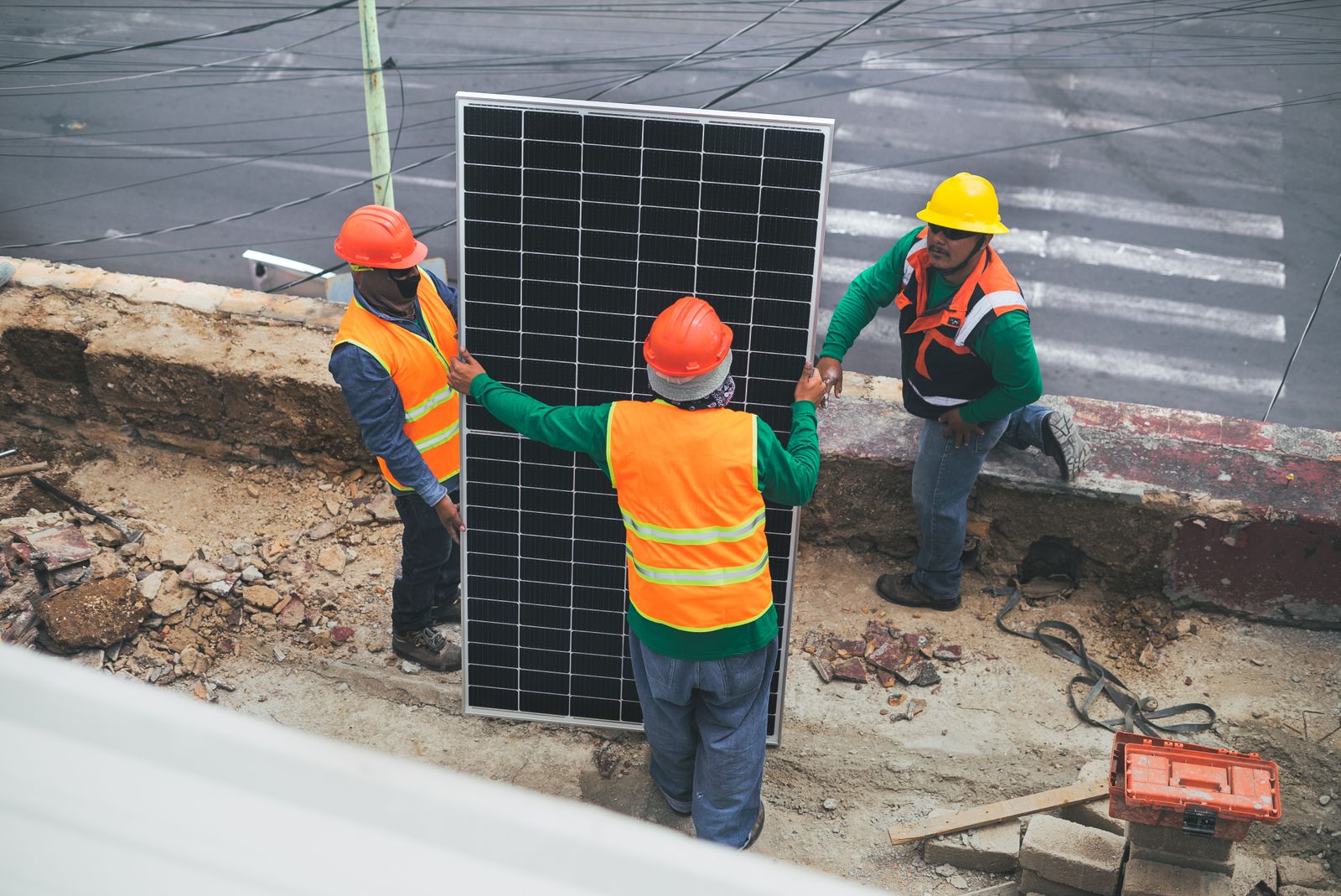 Operarios cargando un panel solar en obra